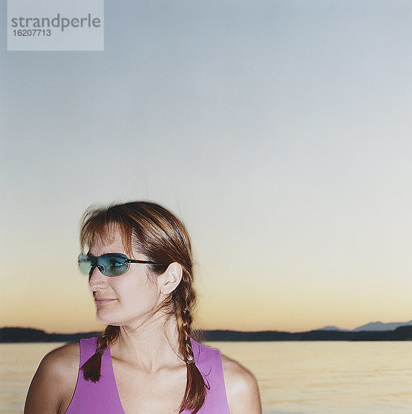 Porträt einer Frau mit Sonnenbrille  Meer in der Ferne