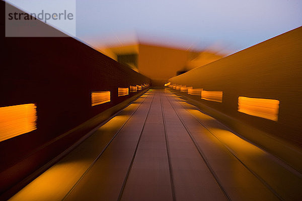 Bewegungsunschärfe  ein farbenfroher Gang mit Balustrade und Sonnenlichtflecken.