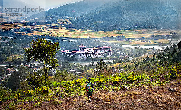 Kleines Kind schaut auf den Punakha Dzong  den zweitgrößten und zweitältesten Dzong in Bhutan  Punakha  Bhutan  Asien