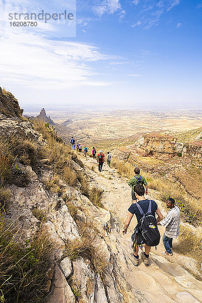 Wanderer wagen sich auf einem Felspfad zu den in Fels gehauenen Kirchen des Gheralta-Gebirges  Region Tigray  Äthiopien  Afrika