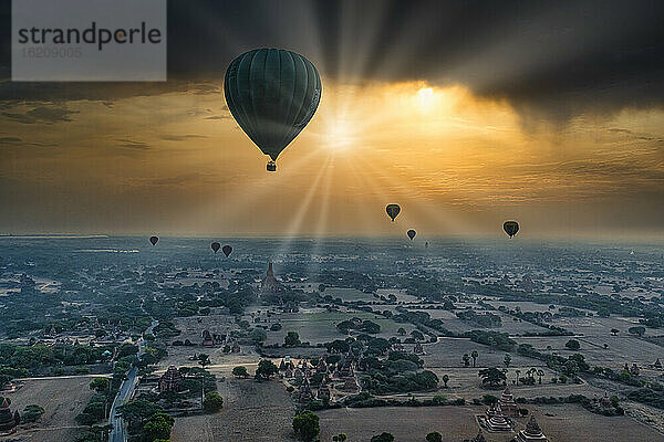 Myanmar  Region Mandalay  Bagan  Heißluftballons fliegen über alte Stupas bei dramatischem Sonnenaufgang