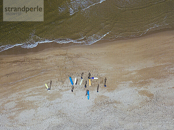 Luftaufnahme von Surfern bei der Vorbereitung auf den Sandstrand an der Küste