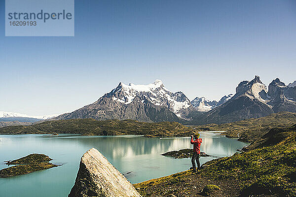 Mann betrachtet den Pehoe-See durch ein Fernglas im Torres Del Paine National Park  Chile Patagonien  Südamerika