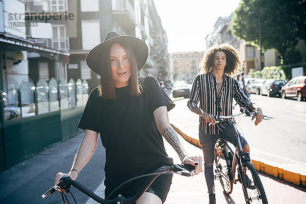Paar auf Fahrrädern auf der Straße in der Stadt an einem sonnigen Tag