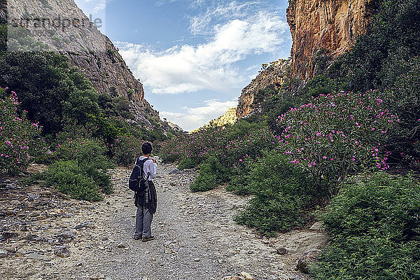 Mann mit Rucksack auf einem Berg in Griechenland stehend