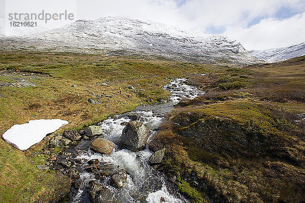 Norwegen  Laerdal  Frau beim Wandern  Bach im Vordergrund