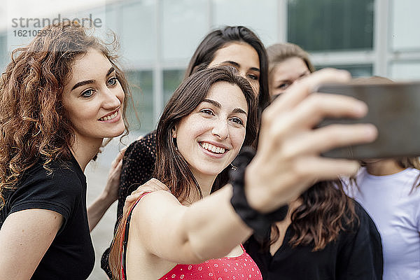 Junge Frau nimmt Selfie mit weiblichen Freunden in der Stadt
