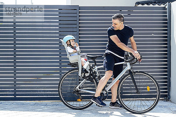 Vater mit Sohn auf dem Sicherheitssitz eines Fahrrads