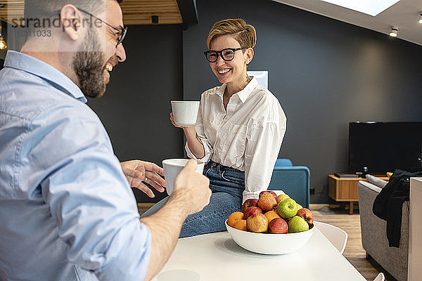 Glückliche weibliche und männliche Fachkräfte genießen die Kaffeepause in der Büro-Cafeteria