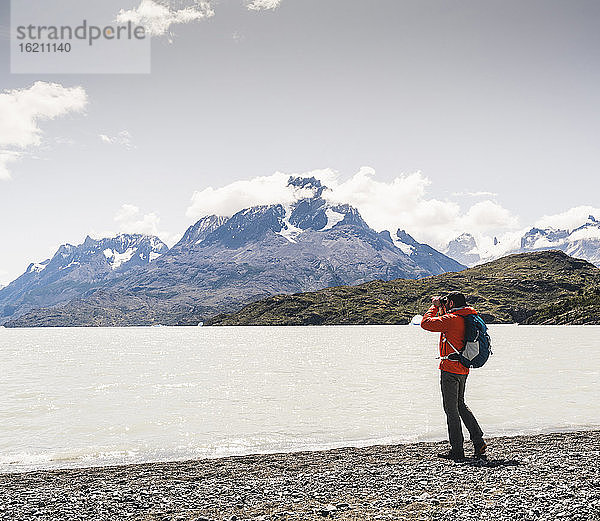 Mann mit Blick auf den Grey Glacier durch ein Fernglas im Torres Del Paine National Park  Patagonien  Chile  Südamerika