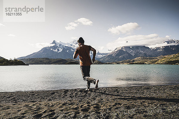 Mann läuft auf Sand am Pehoe-See im Torres Del Paine National Park Patagonien  Südamerika