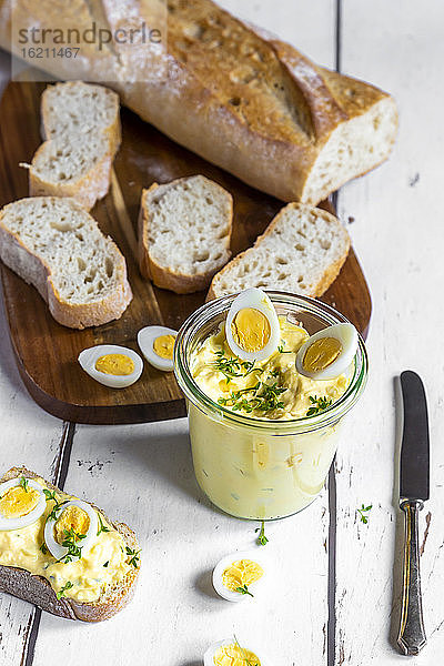 Aufgeschnittenes Baguette und ein Glas hausgemachter Eiersalat mit Kresse
