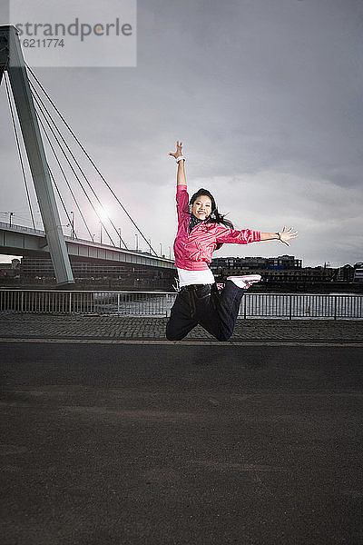 Deutschland  Köln  Junge Frau springend  Porträt