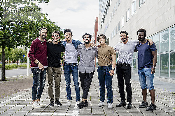 Coole männliche Freunde posieren auf einem Fußweg in der Stadt