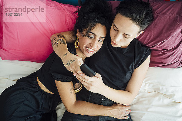 Lesbisches Paar textet im Schlafzimmer