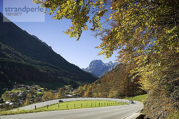 Deutschland  Bayern  Auto auf Straße mit Bergen im Hintergrund