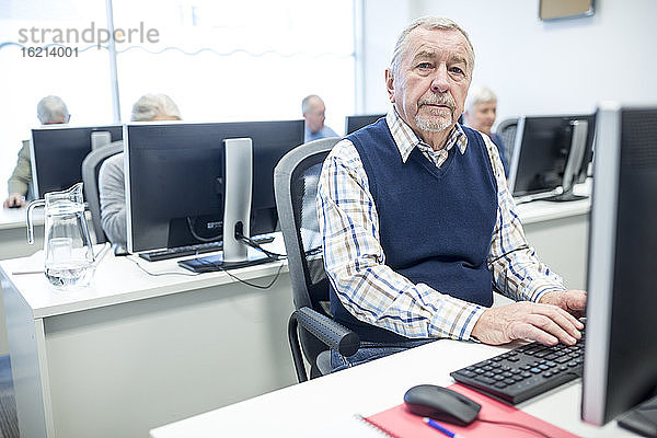 Ein älterer Mann besucht einen Computerkurs