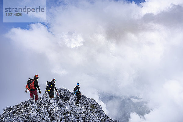 Ältere Männer wandern auf einem Berg vor bewölktem Himmel  Bergamasker Alpen  Italien