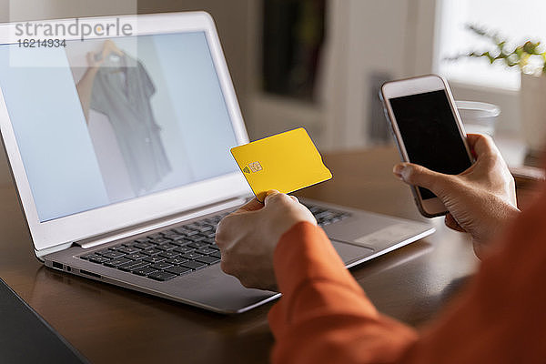 Ausgeschnittenes Bild einer Geschäftsfrau mit Kreditkarte  die ihr Smartphone beim Online-Einkauf zu Hause benutzt
