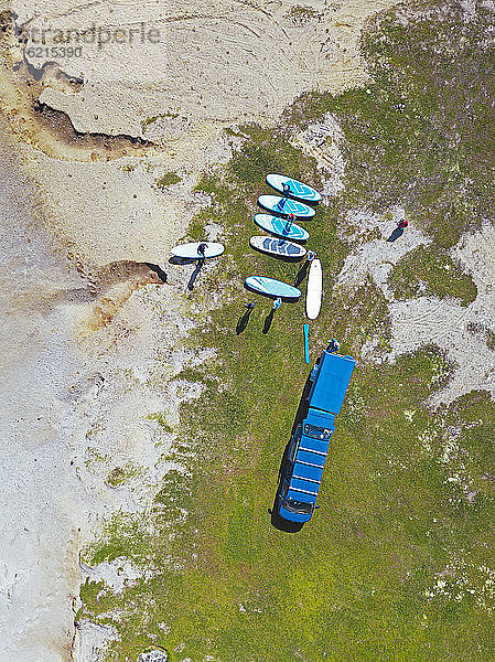 Luftaufnahme von Surfern  die sich am sandigen Flussufer vorbereiten