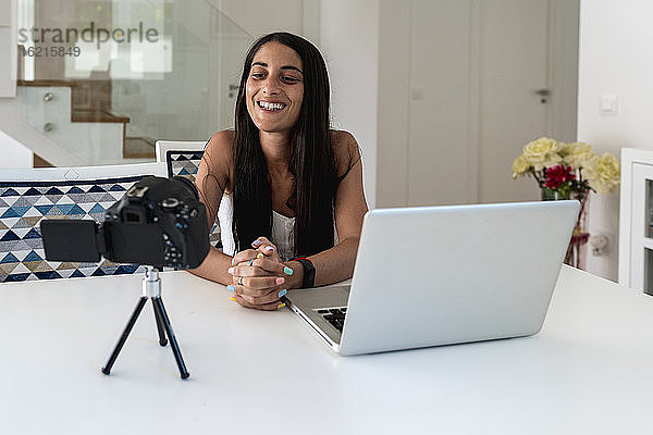 Bloggerin  die zu Hause ein Video mit der Kamera auf dem Tisch aufnimmt