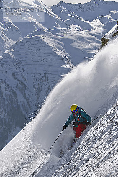 Österreich  Mann beim Skifahren auf schneebedeckten Bergen