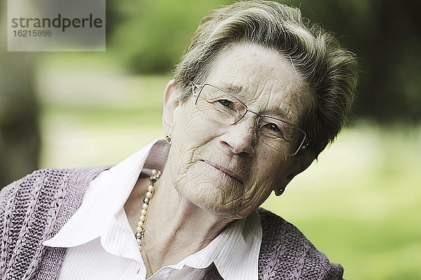 Deutschland  Köln  Porträt einer älteren Frau im Park  lächelnd