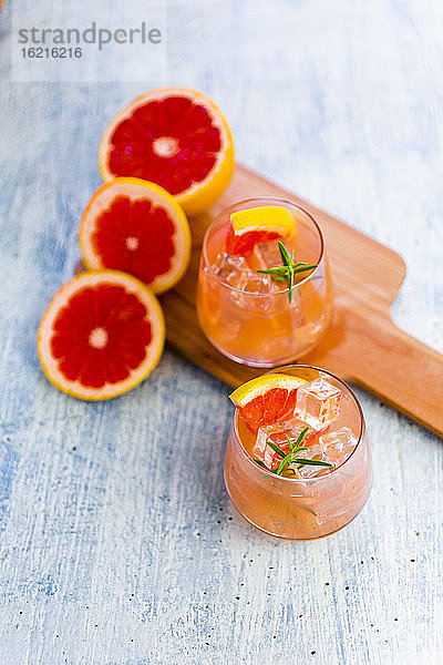Gläser mit frischem Grapefruitsaft und Grapefruits