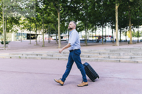Geschäftsmann zu Fuß mit Koffer im Büropark