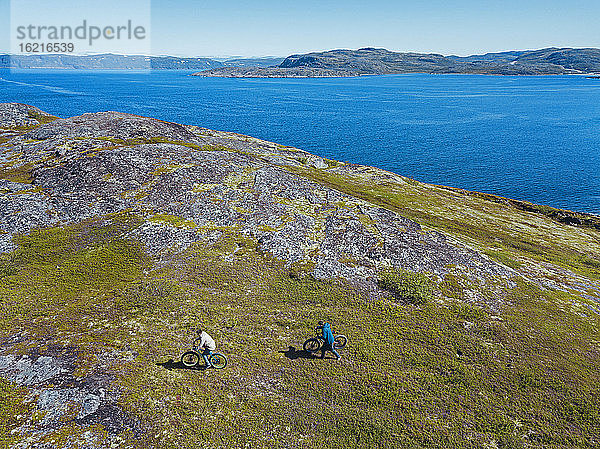 Russland  Gebiet Murmansk  Bezirk Kolsky  Teriberka  Zwei Männer mit Fahrrädern an der Küste  Luftaufnahme