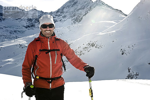 Österreich  Mann beim Skifahren am Berg im Salzburger Land  lächelnd