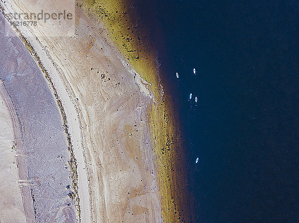 Luftaufnahme von Menschen beim Surfen am sandigen Ufer des Flusses Teriberka