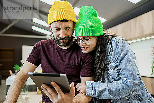 Glückliches Geschäftspaar verwendet digitales Tablet in einem modernen Büro