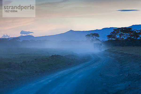Afrika  Kenia  Blick auf Safari mit viel Staub in der Abenddämmerung