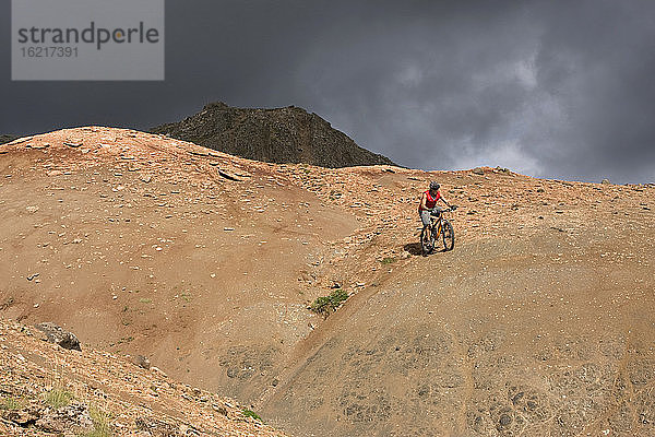 Island  Mann beim Mountainbiking in hügeliger Landschaft