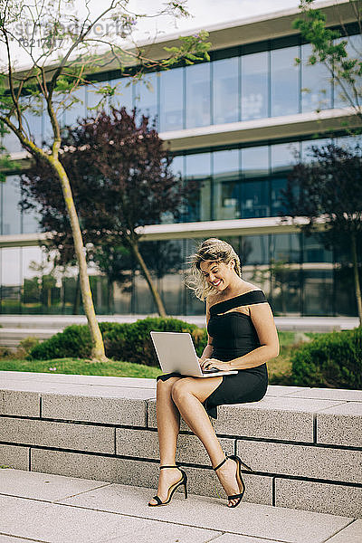 Geschäftsfrau arbeitet an einem Laptop im Freien