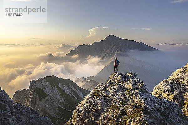 Wanderer  der auf einem Berggipfel in den Bergamasker Alpen  Italien  steht und die atemberaubende Aussicht bewundert