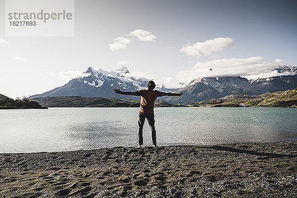 Mann mit ausgestreckten Armen am Pehoe-See im Torres Del Paine National Park in Patagonien  Südamerika