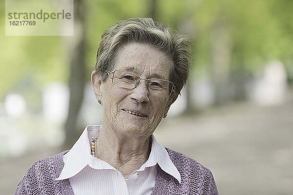 Deutschland  Köln  Porträt einer älteren Frau im Park  lächelnd