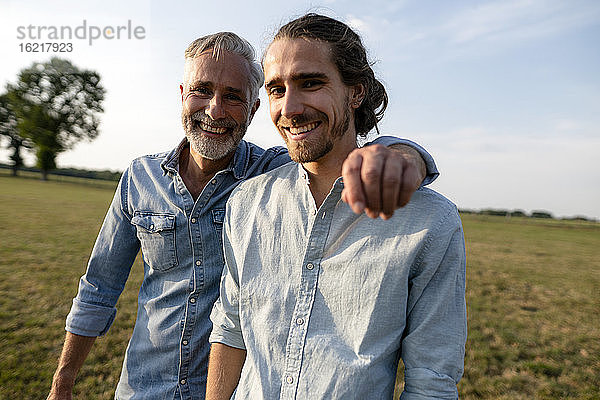 Porträt eines glücklichen Vaters mit einem erwachsenen Sohn auf einer Wiese in der Natur