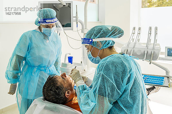 Arzt und Krankenschwester mit männlichem Patienten in der Zahnklinik