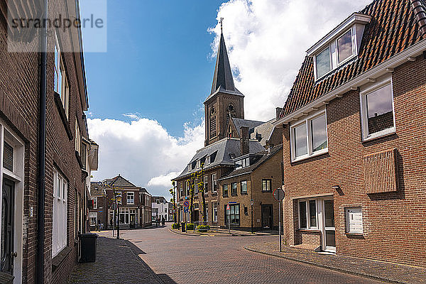 Niederlande  Südholland  Noordwijk  Leere Stadtstraße mit Kirchturm im Hintergrund