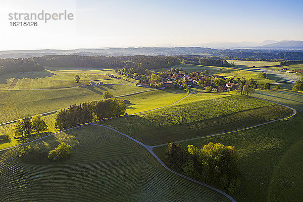 Deutschland  Bayern  Peretshofen  Drohnenansicht eines ländlichen Dorfes bei Sonnenuntergang