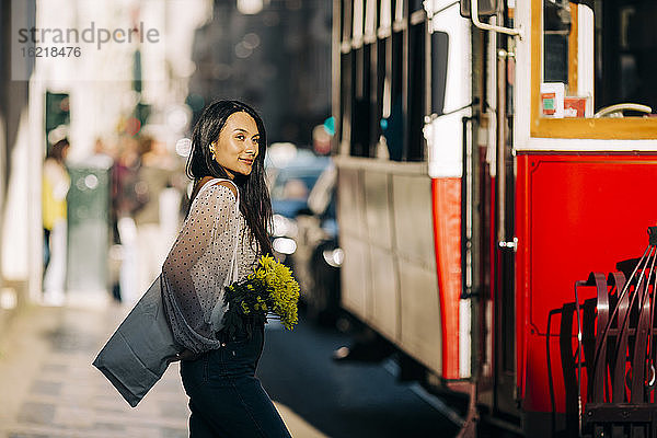 Junge Frau an der Straßenbahn in der Stadt
