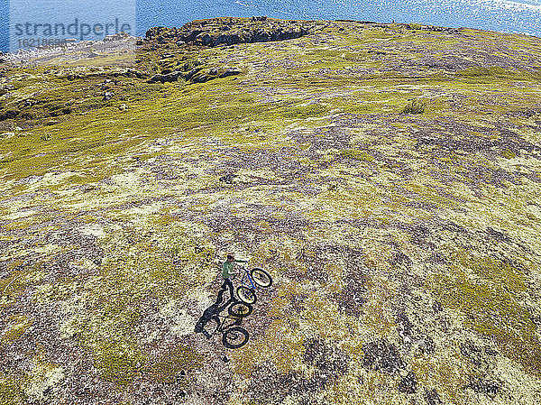Russland  Gebiet Murmansk  Bezirk Kolsky  Teriberka  Mann mit Fahrrad an der Küste  Luftaufnahme