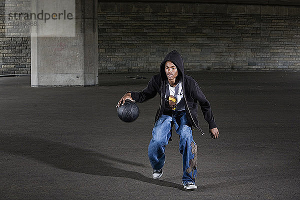 Deutschland  Köln  Junger Mann spielt Basketball  Porträt