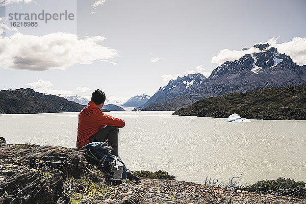 Mann schaut auf einen Fluss  während er im Torres Del Paine National Park sitzt  Patagonien  Chile  Südamerika