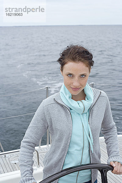 Junge Frau am Steuerrad eines Schiffes  Porträt