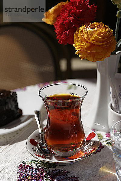 Türkei  Alacati  Schwarzer Tee auf Tisch mit Blumenvase