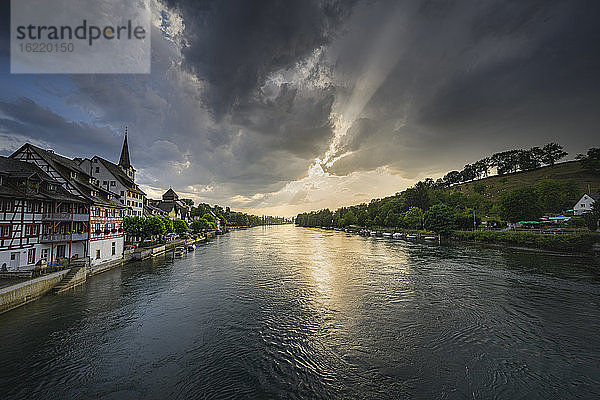 Schweiz  Kanton Thurgau  Diessenhofen  Hochrhein und angrenzendes Dorf bei grau bewölktem Sonnenuntergang